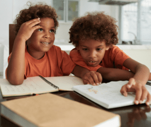 Siblings support each other doing homework.