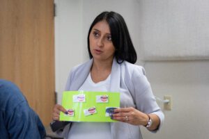 A feeding therapist holds up a green visual aid