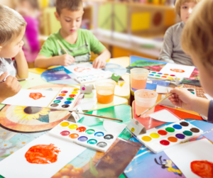 A group of children paint.