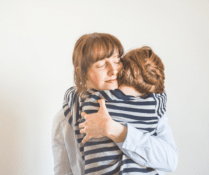 Mother hugs son with red hair