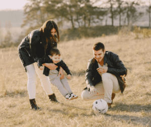 Parents play in field with child