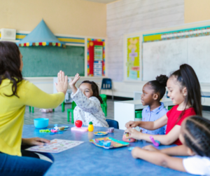 A teacher high fives a student