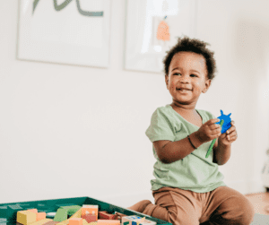 A young boy holds a blue toy.