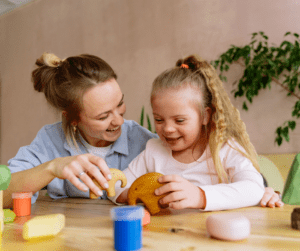 A therapist plays with blocks with a young girl.