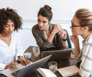 A group of BCBAs gather around computers.