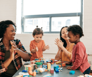 A therapist and children clap.