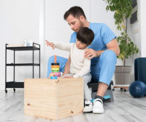 BCBA helps toddler boy play with blocks