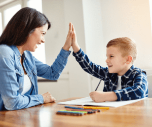 Adult and child high five during ABA assessment